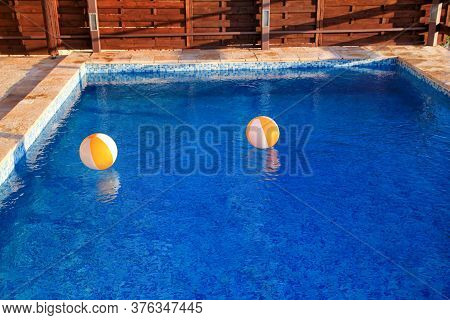 Two Rubber Air Yellow White Inflatable Balls And Toy For Swimming Pool In Transparent Blue Water. Mu
