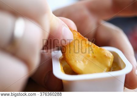 Close-up Of Male Hand Holding Dipping Potatoes And Sauce In Plastic Container. Yummy Snack For Quick