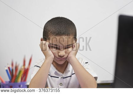 Bored Schoolboy Looking Tired Of Doing Homeworks. Kid Trying To Concentrate. Doing Online Classwork 