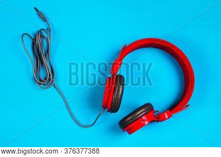 Red Headphones On Blue Background. Music Concept