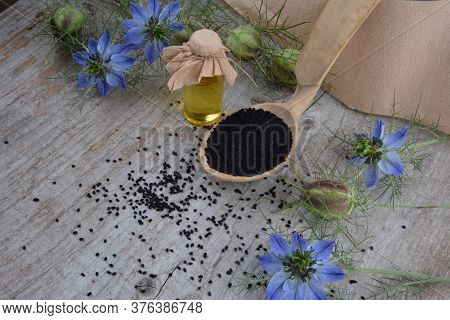 Black Cumin (nigella Sativa Or Kalonji) Seeds In Heart-shaped Bowl On Wooden Background