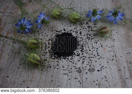 Black Cumin (nigella Sativa Or Kalonji) Seeds In Heart-shaped Bowl On Wooden Background