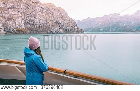 Alaska cruise Inside passage travel tourist woman looking at mountains landscape from balcony deck of ship. Glacier bay scenic vacation travel holiday.