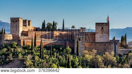 View Of Alhambra Palace In Granada, Spain With Sierra Nevada Mountains At The Background