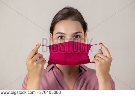 Attractive Medical Worker About To Put On An Earloop Face Mask