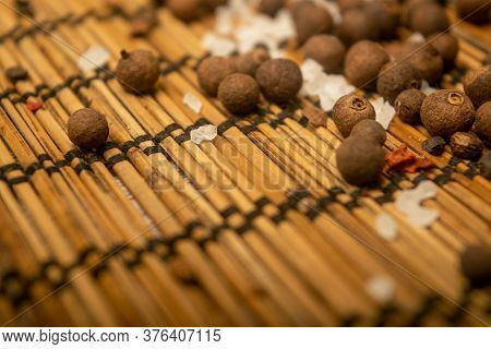 Fragrant Black Pepper And Coarse Sea Salt In Bulk On A Reed Mat. Close Up.