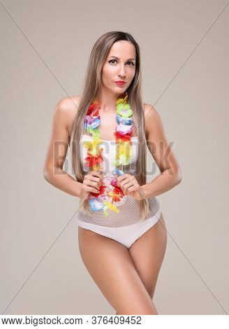 Beautiful Slim And Fit Girl With Long Blond Hair In Whiteswimsuit. Glowing Skin