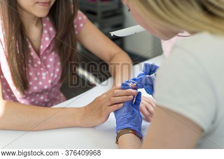 Processing A Cuticle, A Manicurist Treats A Young Girl Of Twenty-seven Years Old Cuticles On Fingern