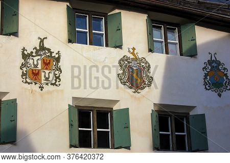 Guarda, Switzerland - Aug 14, 2009: Facade Of An Ancient House With Windows And Coat Of Arms In The 