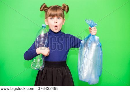 Girl Hold Trash Bag And Plastic Bottle And Shows Interest In Environmental Issues Isolated On Green 