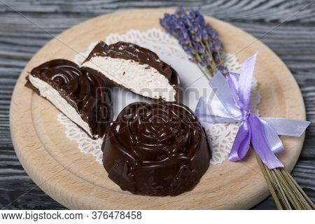 A Chocolate Zephyr Made In The Shape Of A Rose Lies On A White Napkin. One Zephyr Is Cut In Half, A