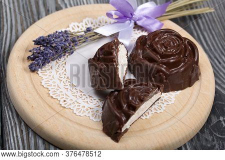 A Chocolate Zephyr Made In The Shape Of A Rose Lies On A White Napkin. One Zephyr Is Cut In Half, A