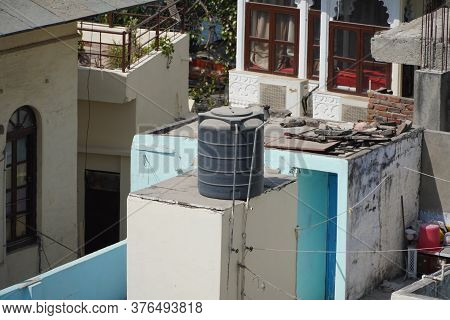 Black Water Tanks Of Industrial Building On Roof Top Or Deck Of An Old Residential Building In A Rur