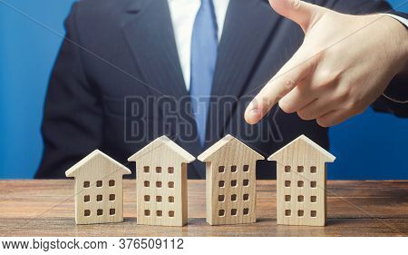 A Man Chooses An Apartment House Among Many Propositions Options In The Real Estate Market. Housing 