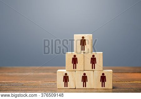 Blocks Pyramid With People. Joint Efforts To Achieve Goal. Teamwork, Cooperation And Collaboration. 