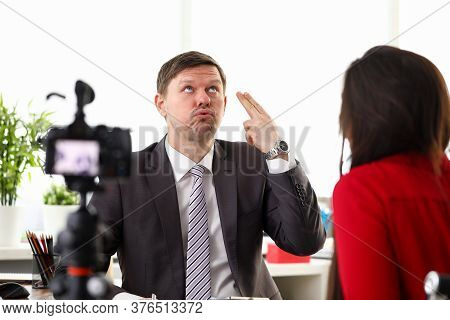 Portrait Of Businessman Giving Interview To Journalist In Office. Man In Presentable Suit With Activ