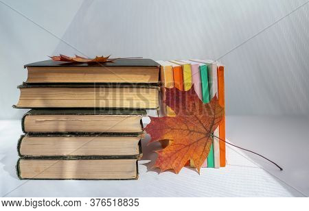 Old Books And Maple Leaves On A Light Background. Clean Place For Text.  Background For Libraries, E