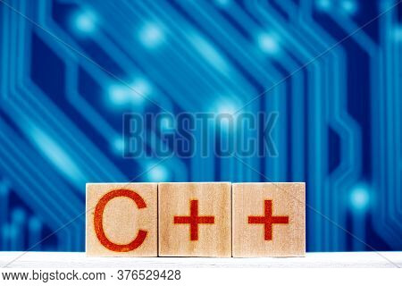 C ++ Concept. Wooden Blocks With C ++ Inscription On A Blue Background With Circuit Board Tracks