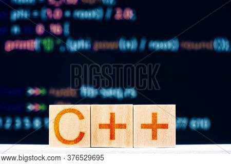 C ++ Concept. Wooden Blocks With The Inscription C ++ And Program Code On The Background