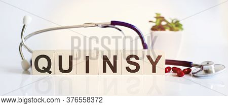 Quinsy The Word Is Written On Wooden Cubes And Sthetoscope And Piils . Medical Concept