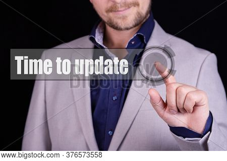Businessman Presses A Button With The Text Time To Update. Business Concept.