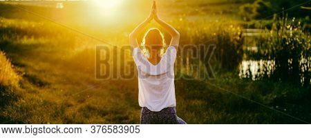 woman in a yoga pose at sunset by lakeside mindfulness and mental health