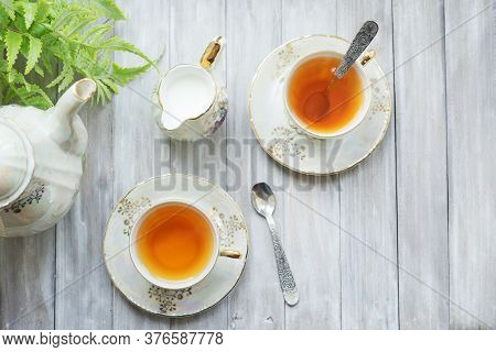 Traditional Five O'clock English Tea In An Elegant China Set. Two Cups Of Tea And Milk On A Wooden V