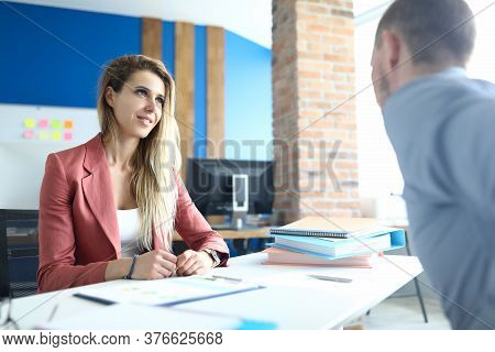 Portrait Of Stylish Young Woman In Presentable Pink Suit Talking To Client. Well Dressed Female Empl