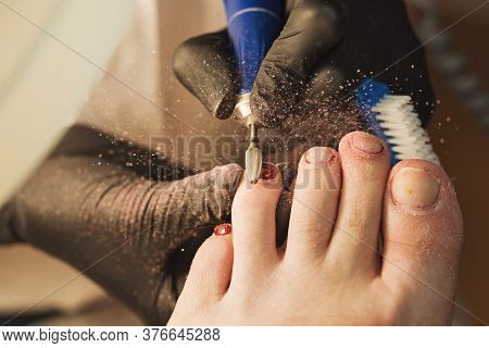Professional Making Pedicure Removing Old Coating In Salon. Master Chiropody Shapes The Nails. Femal
