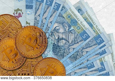5 Ukrainian Hryvnias Bills And Golden Bitcoins. Cryptocurrency Investment Concept. Crypto Mining Or 
