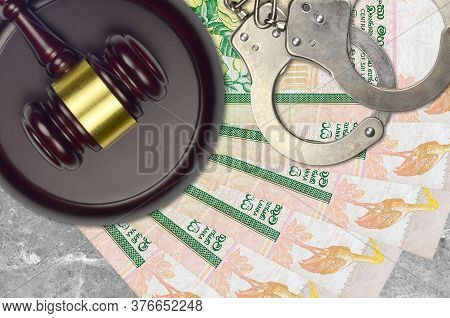 10 Sri Lankan Rupees Bills And Judge Hammer With Police Handcuffs On Court Desk. Concept Of Judicial