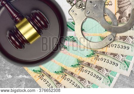 10 Sri Lankan Rupees Bills And Judge Hammer With Police Handcuffs On Court Desk. Concept Of Judicial
