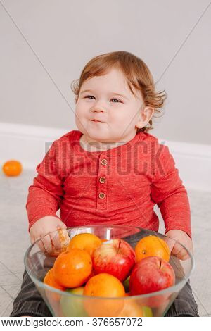 Cute Adorable Caucasian Baby Boy Eating Citrus Fruit. Finny Child Eating Healthy Organic Seasonal Su