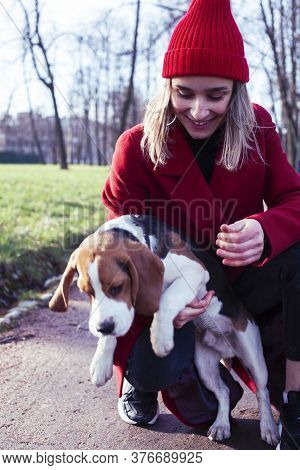 Pretty Young Girl In Redd Coat Playing With Dog Outside In Green Park, Lifestyle People Concept