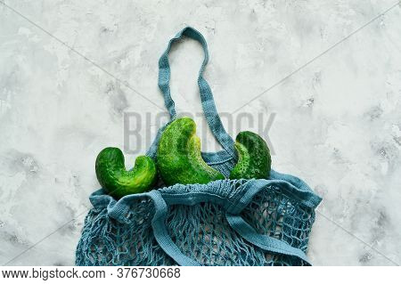 Trendy Ugly Vegetables. Fresh Ugly Cucumbers On A Concrete, Background In A String Bag. Imperfect Fo