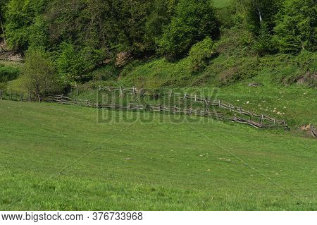Panorama Of A Typical Alpine Meadow With Wood Fence.
Mountain And Valley