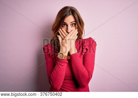 Young beautiful brunette woman wearing casual sweater stnding over pink background shocked covering mouth with hands for mistake. Secret concept.