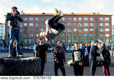 Norilsk, Russia - August, 28, 2016: Young Teenager Jumps And Does Somersaults. Parkour On The Street