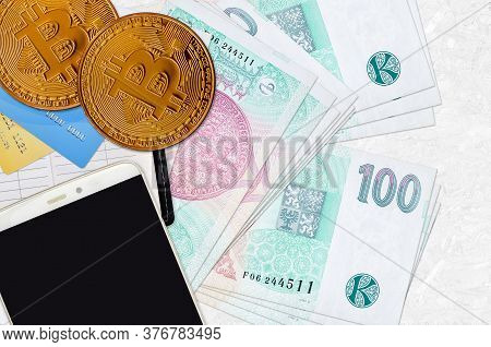 100 Czech Korun Bills And Golden Bitcoins With Smartphone And Credit Cards. Cryptocurrency Investmen