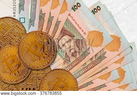 100 Ukrainian Hryvnias Bills And Golden Bitcoins. Cryptocurrency Investment Concept. Crypto Mining O