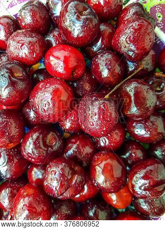 Bright Juicy Ripe Cherry On A Dark Background.