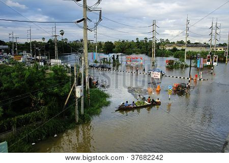 Unidentified people have to travel by boat on the road during flood