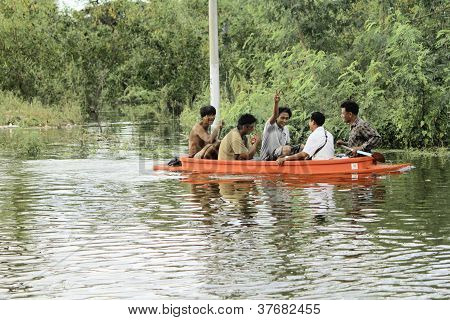 Unidentified people have to travel by boat on the road during flood