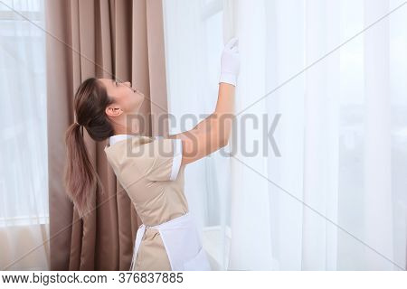 A Maid In White Gloves And Uniform Is Airing The Room In A Hotel Room Or Apartment. The Concept Of T