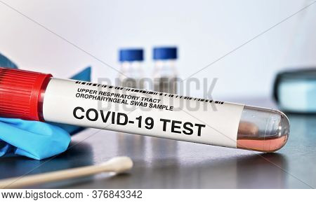 Coronavirus Test Concept - Vial Sample Tube With Cotton Swab, Blue Gloves Near, Blurred Lab Glass Ba