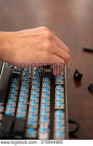 Caucasian technician repairing a mechanical keyboard with blue switches