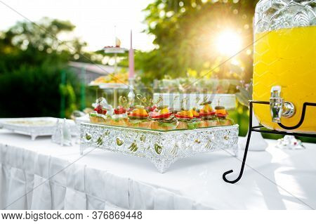 Sunny Summer Banquet Table With Tappas Canape And Lemonade Jar