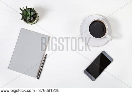 White Minimal Office Desk Table With Smartfone, Grey Closed Copybook, Pen And Small Cactus Plant, Cu