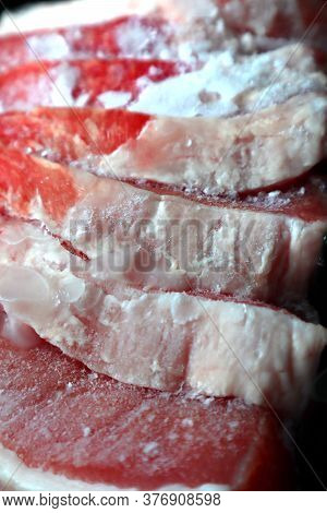 Sliced Frozen Pieces Of Meat. There Are Pieces Of Ice On The Pieces Of Meat.