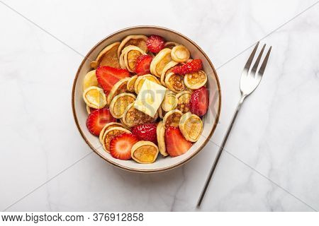 Trendy Home Breakfast With Tiny Cereal Pancakes With Piece Of Butter And Fresh Strawberries In The B